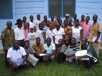 Group of men standing by a trailer loaded with wheelbarrows and construction materials in Ghana